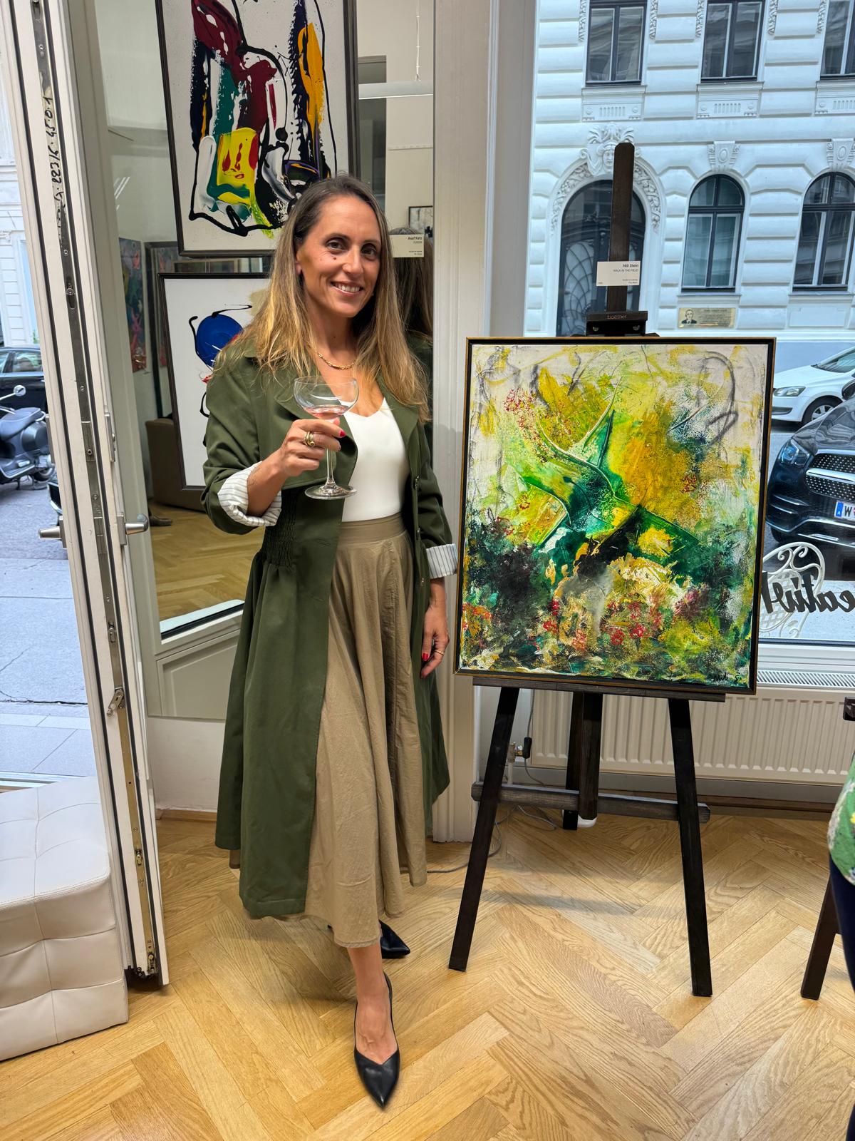 Nili Stein beside her painting Walk in the Fields at KreativeRaum Galerie, Vienna